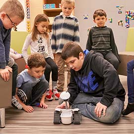 Dans l’espace 21e de l’École élémentaire catholique Sainte-Marguerite-Bourgeoys de Brantford, baptisé « Imaginarium », Jesse explique aux élèves plus jeunes comment fonctionne le robot. 