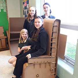 Des élèves de 7e année de l’ÉSC Père-René-de-Galinée posent fièrement avec la chaise qu’elles ont conçue dans le cadre du cours de science et technologie du Programme d’étude intermédiaire de l’IB. Cette chaise, faite uniquement de carton et de colle, peut soutenir le poids d’un élève de 7e !
